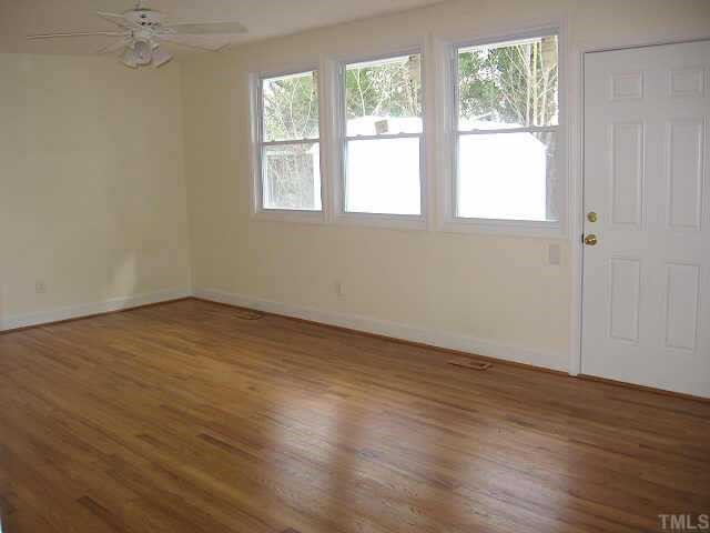 726 East Whitaker Mill Road Raleigh, NC 27608 - Photo 2 of 8 an empty room with wooden floor and windows