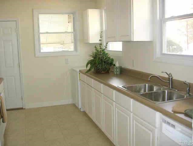 726 East Whitaker Mill Road Raleigh, NC 27608 - Photo 5 of 8 a kitchen with granite countertop a sink white cabinets and a window