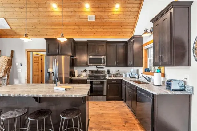 a kitchen with stainless steel appliances granite countertop a sink a stove and a refrigerator