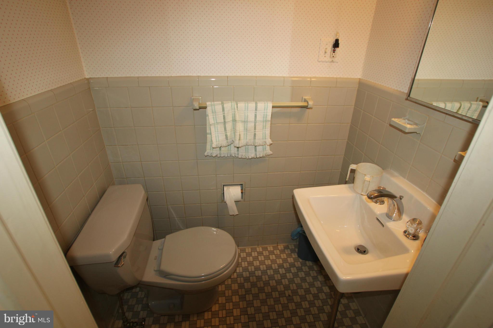 3511 Labyrinth Road Baltimore, MD 21215 - Photo 9 of 20 a bathroom with a sink toilet and mirror