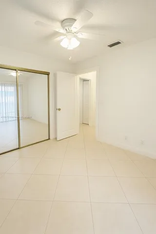 an empty room with fan and glass door