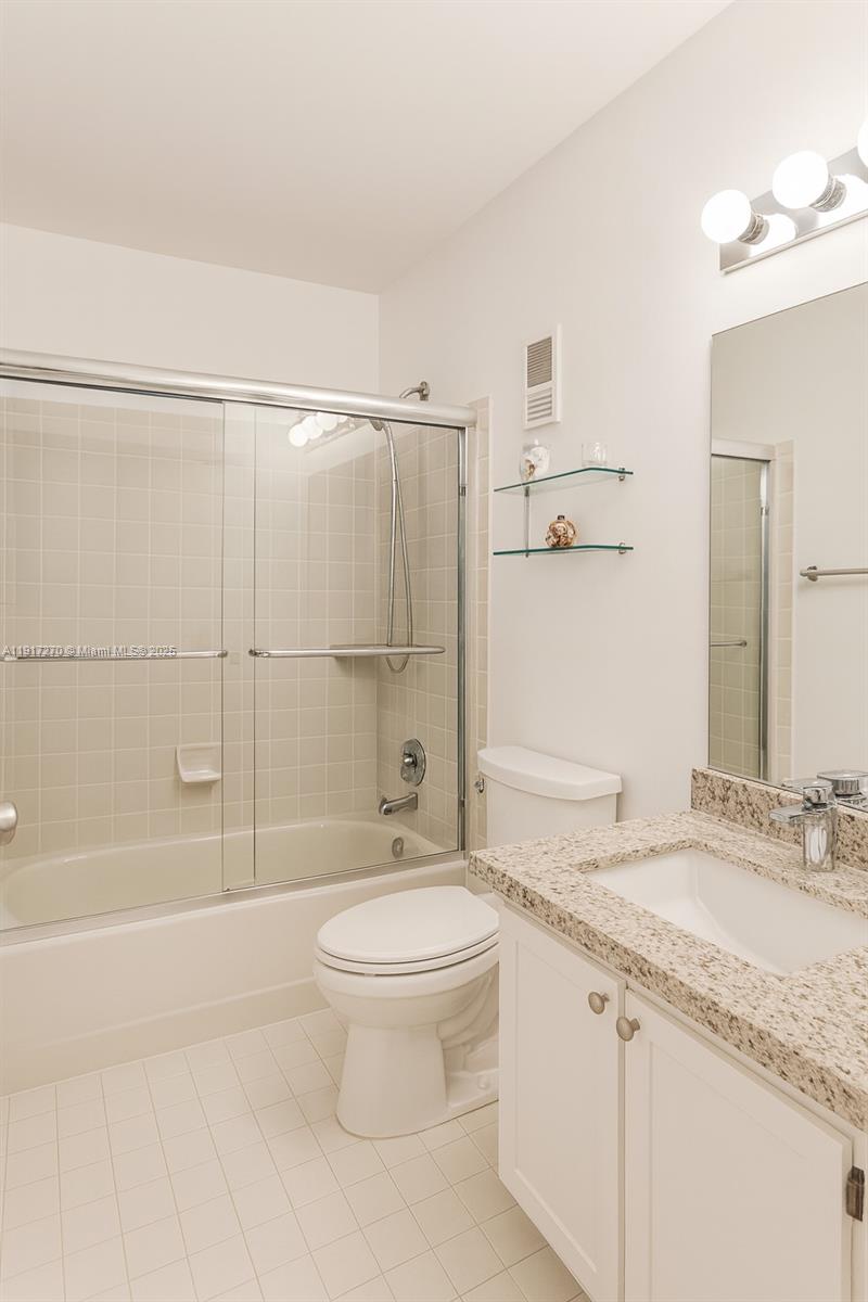 8190 Springtree Road, Unit 8190 Boca Raton, FL 33496 - Photo 12 of 23 a bathroom with a granite countertop sink a toilet and shower