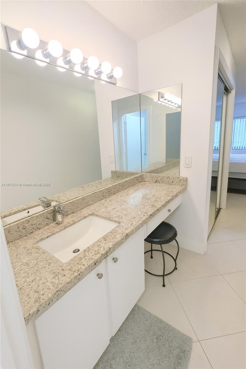 8190 Springtree Road, Unit 8190 Boca Raton, FL 33496 - Photo 17 of 23 a bathroom with a granite countertop sink and a mirror