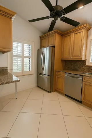 a kitchen with stainless steel appliances granite countertop a refrigerator and a sink