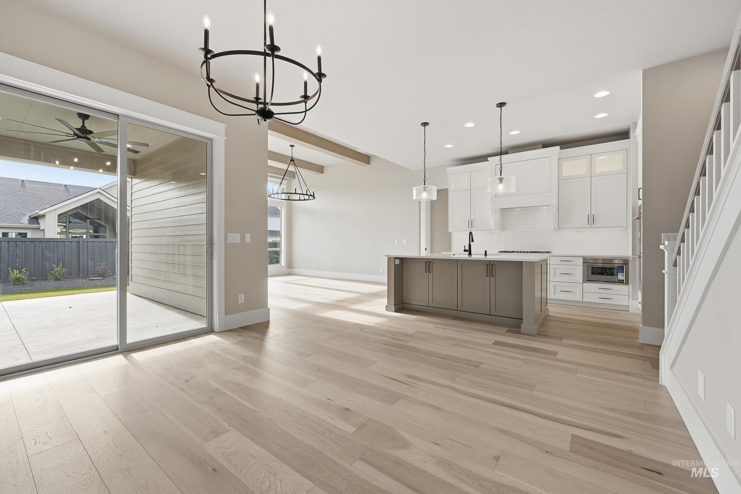 1035 East Crescendo Street Meridian, ID 83642 - Photo 11 of 50 Kitchen with white cabinets, ceiling fan, decorative light fixtures, light wood-style floors, and backsplash