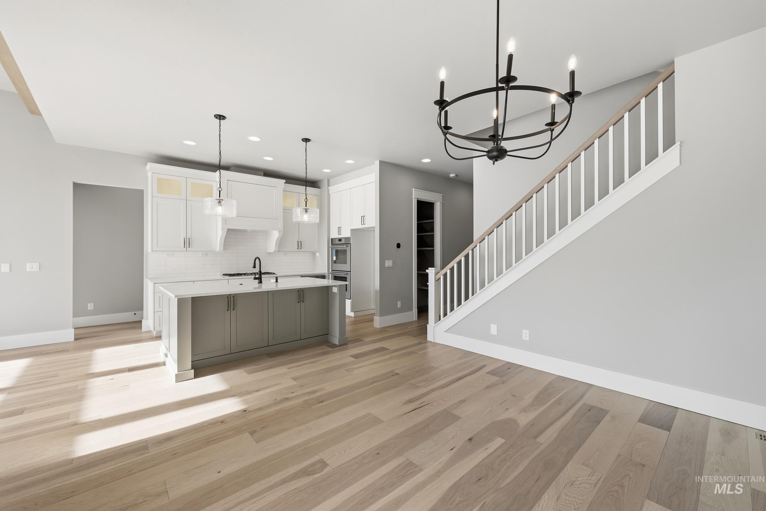 1035 East Crescendo Street Meridian, ID 83642 - Photo 17 of 50 Kitchen featuring an island with sink, white cabinetry, hanging light fixtures, decorative backsplash, and recessed lighting