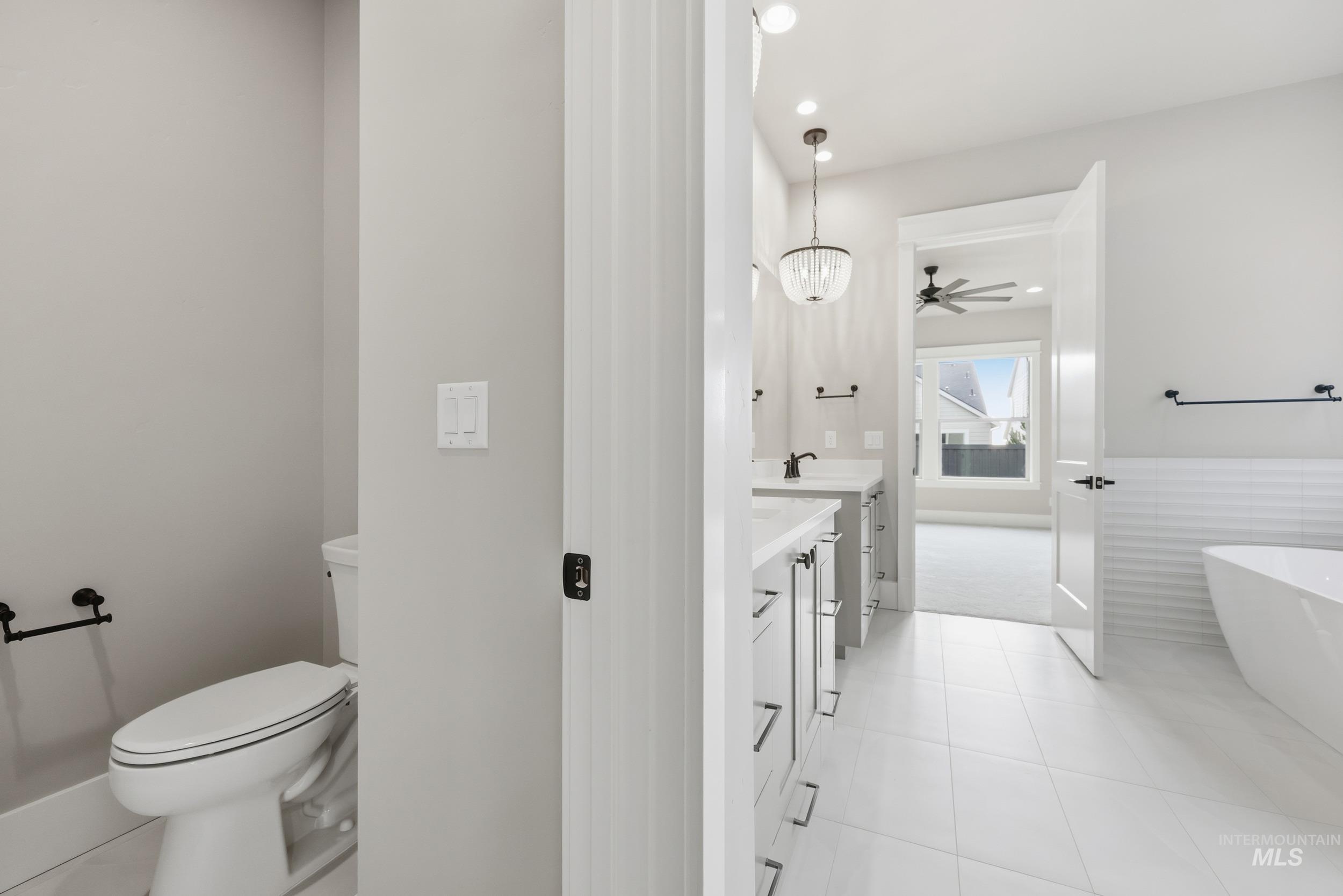 1035 East Crescendo Street Meridian, ID 83642 - Photo 21 of 50 Bathroom featuring vanity, a freestanding tub, light tile patterned flooring, recessed lighting, and a chandelier