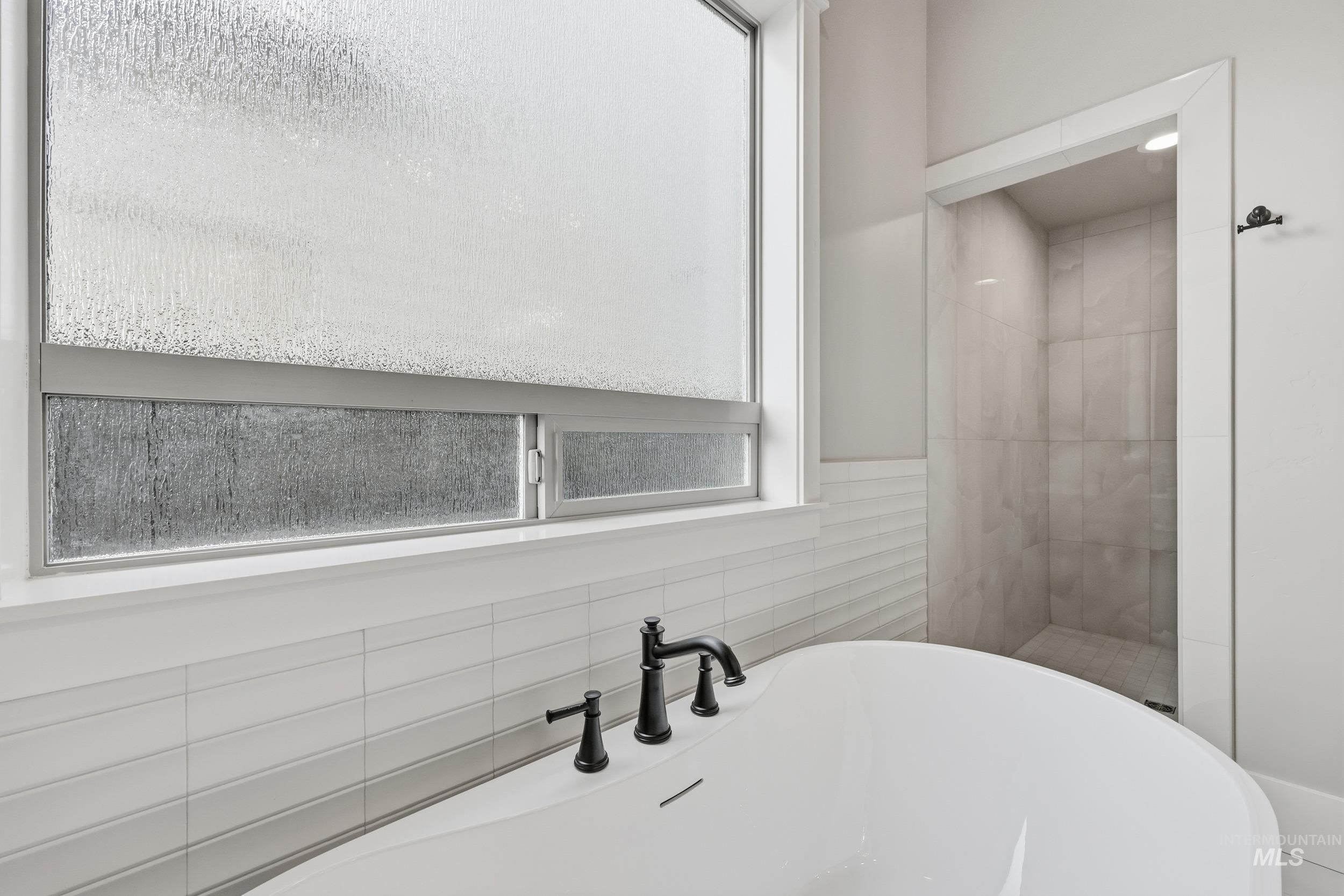 1035 East Crescendo Street Meridian, ID 83642 - Photo 22 of 50 Bathroom featuring a freestanding tub, tile walls, and a tile shower