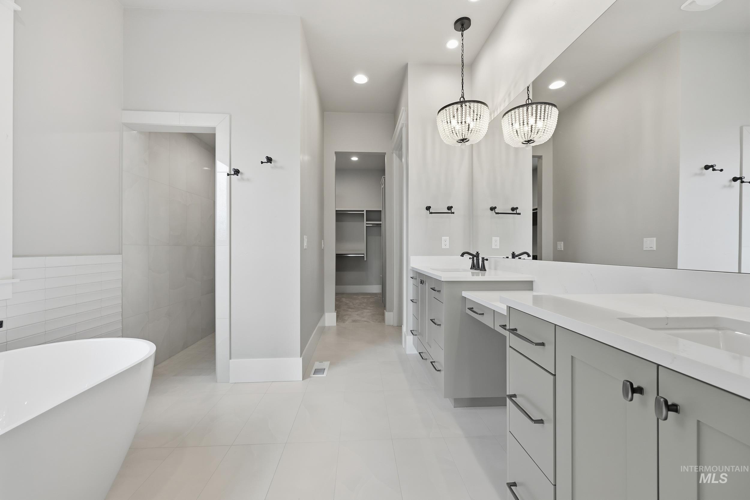 1035 East Crescendo Street Meridian, ID 83642 - Photo 23 of 50 Full bathroom featuring a spacious closet, recessed lighting, two vanities, a freestanding tub, and a chandelier
