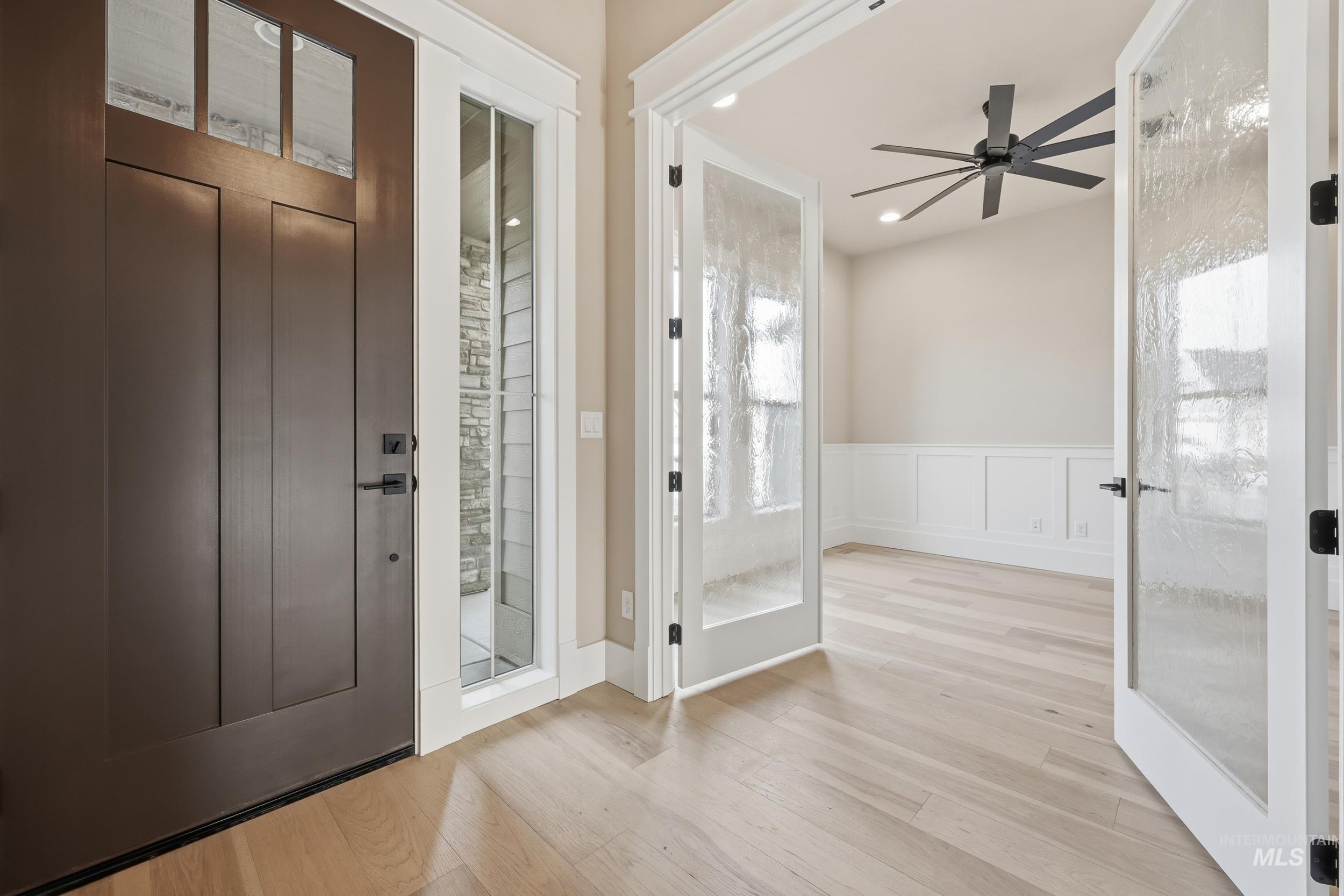 1035 East Crescendo Street Meridian, ID 83642 - Photo 30 of 50 Entrance foyer featuring wainscoting, light wood-style flooring, a decorative wall, and a ceiling fan