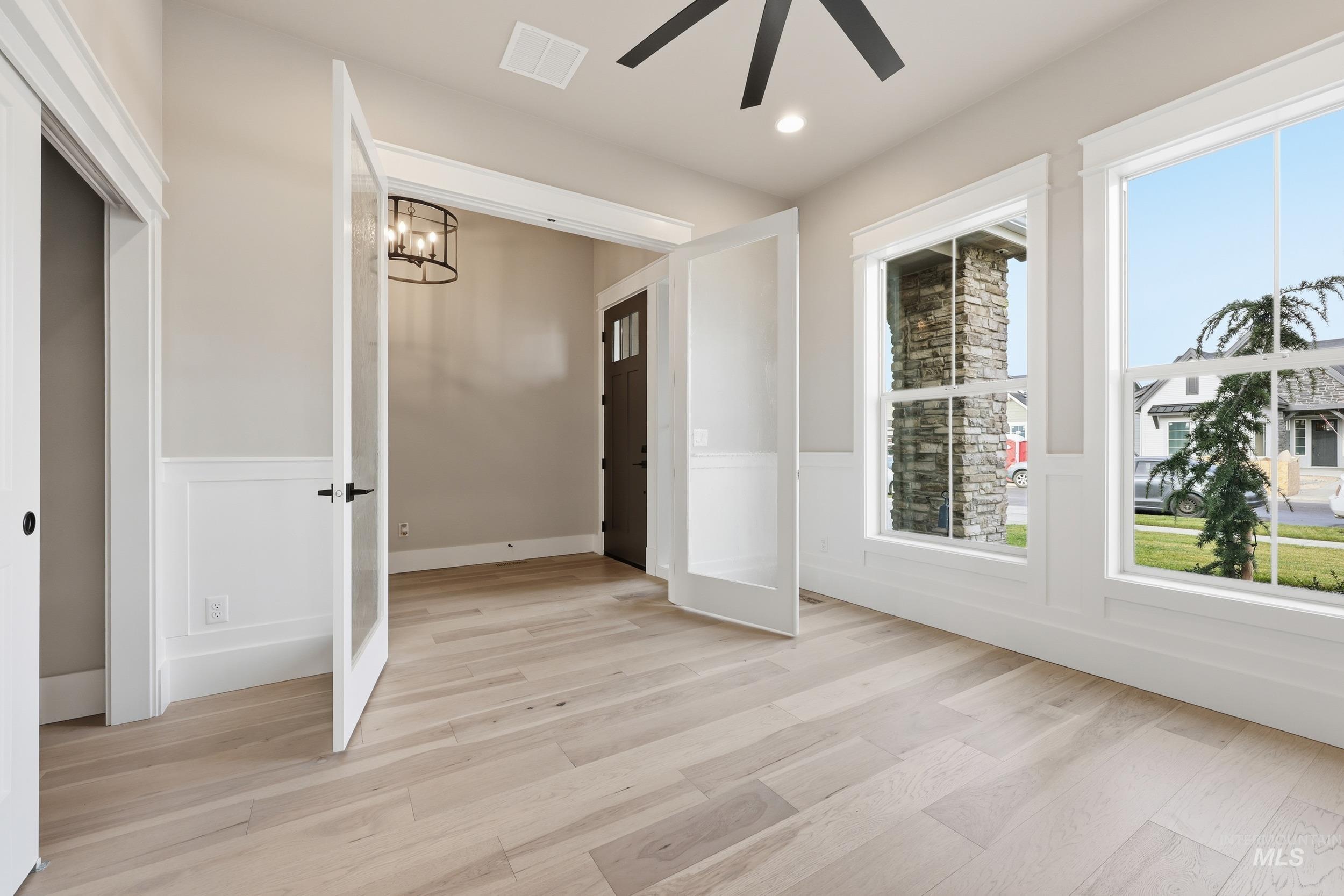 1035 East Crescendo Street Meridian, ID 83642 - Photo 31 of 50 Spare room with light wood-style flooring, a chandelier, a wainscoted wall, recessed lighting, and a decorative wall