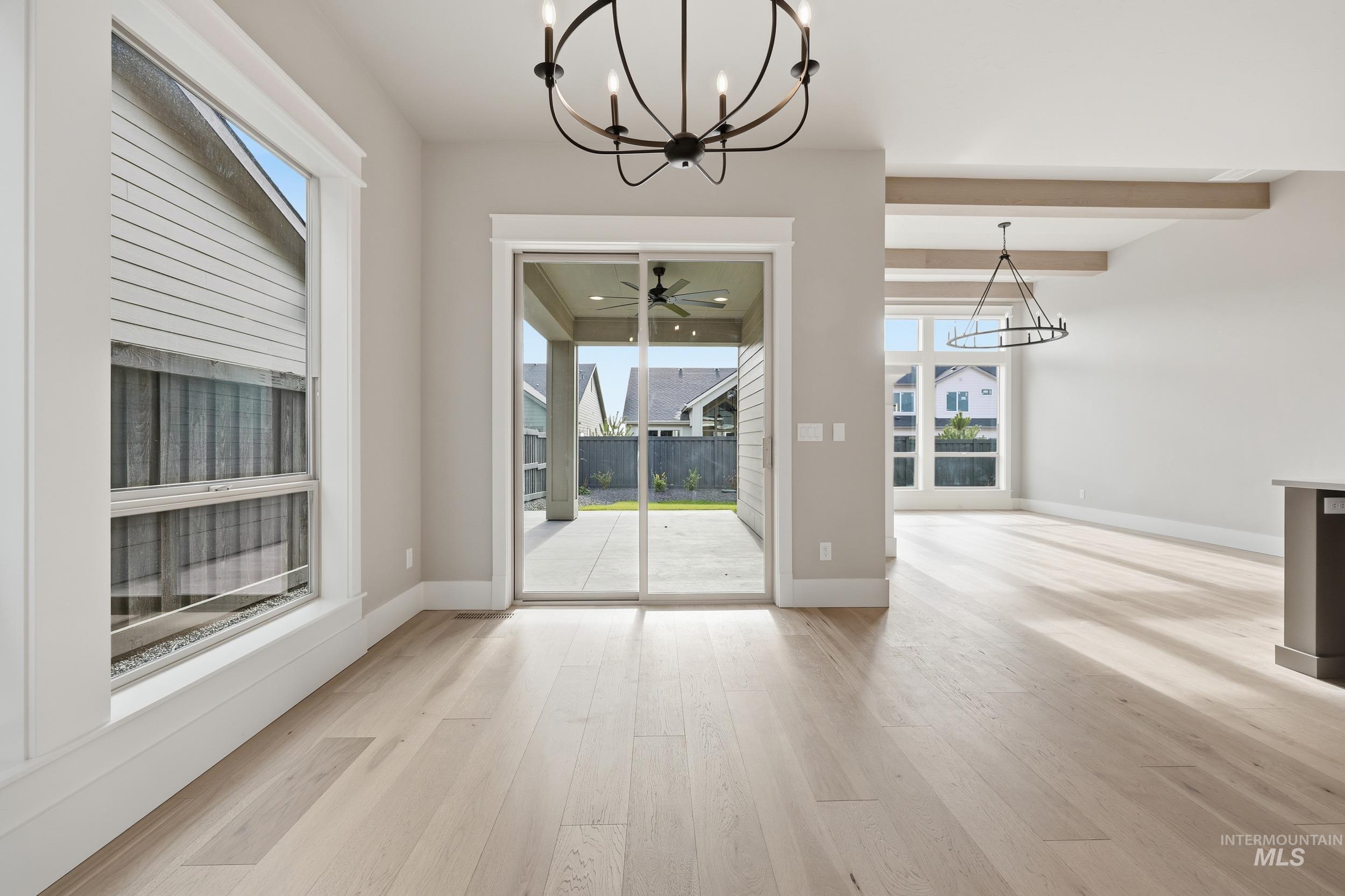 1035 East Crescendo Street Meridian, ID 83642 - Photo 10 of 50 Unfurnished dining area with a chandelier, light wood-style floors, ceiling fan, and beamed ceiling