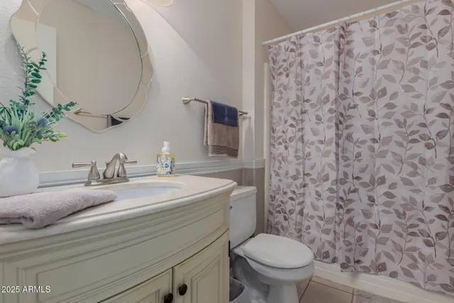 a bathroom with a granite countertop toilet sink and mirror