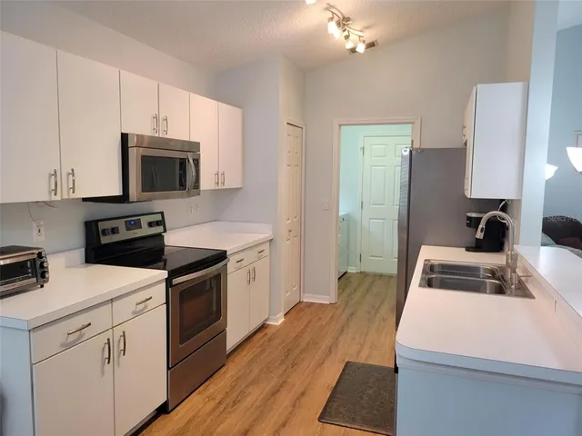 a kitchen with a sink a stove and cabinets