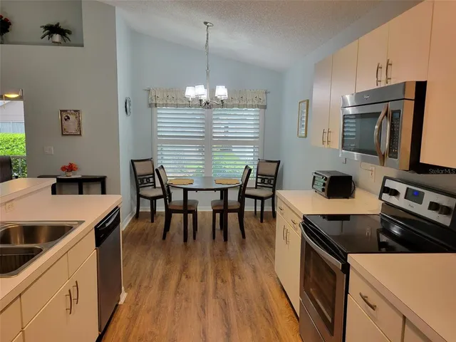 a kitchen that has a table chairs in it and wooden floors