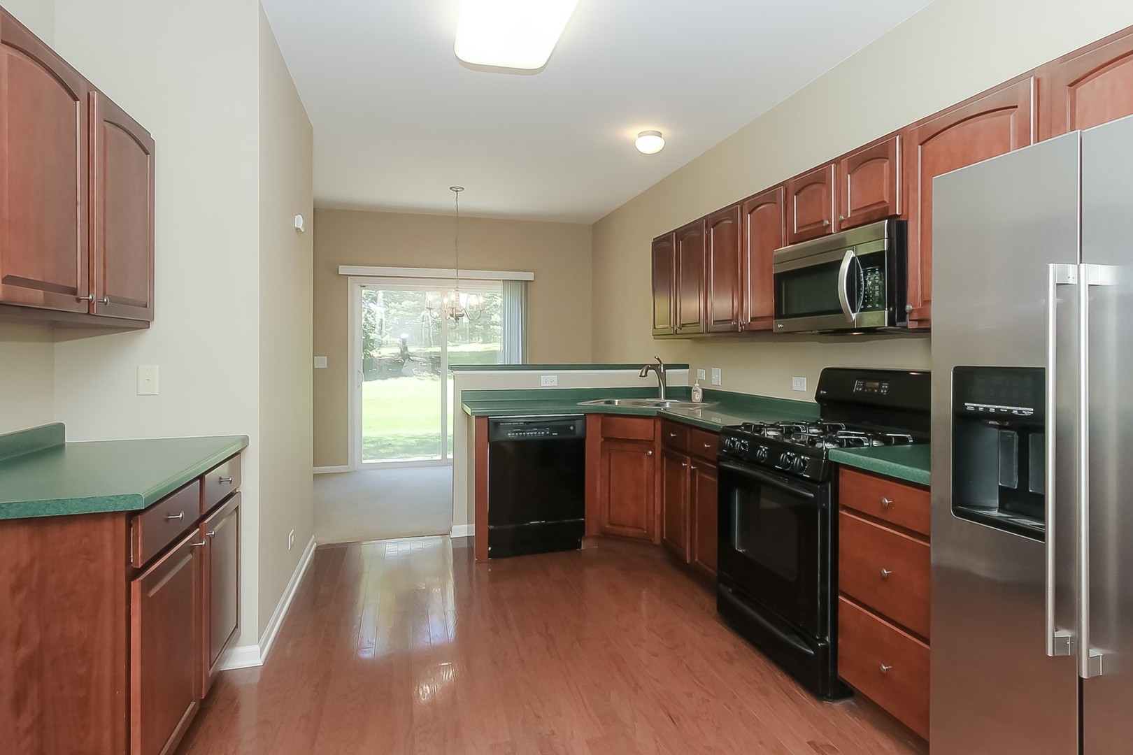 112 Durango Drive Gilberts, IL 60136 - Photo 10 of 24 a kitchen with stainless steel appliances granite countertop a stove a sink and a microwave