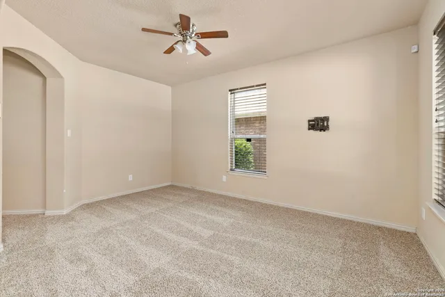 a view of room with hardwood floor and ceiling fan