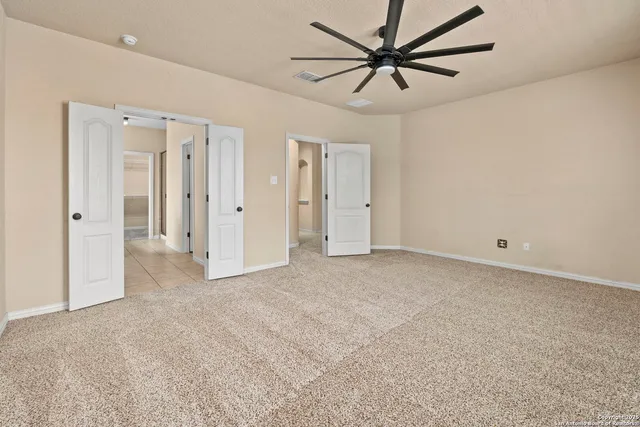 an empty room with chandelier fan