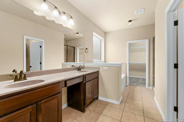 a spacious bathroom with a double vanity sink a and a mirror