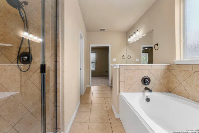 a bathroom with a tub sink and mirror
