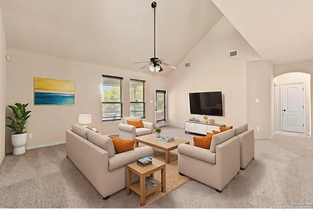 a living room with furniture a flat screen tv and a large window