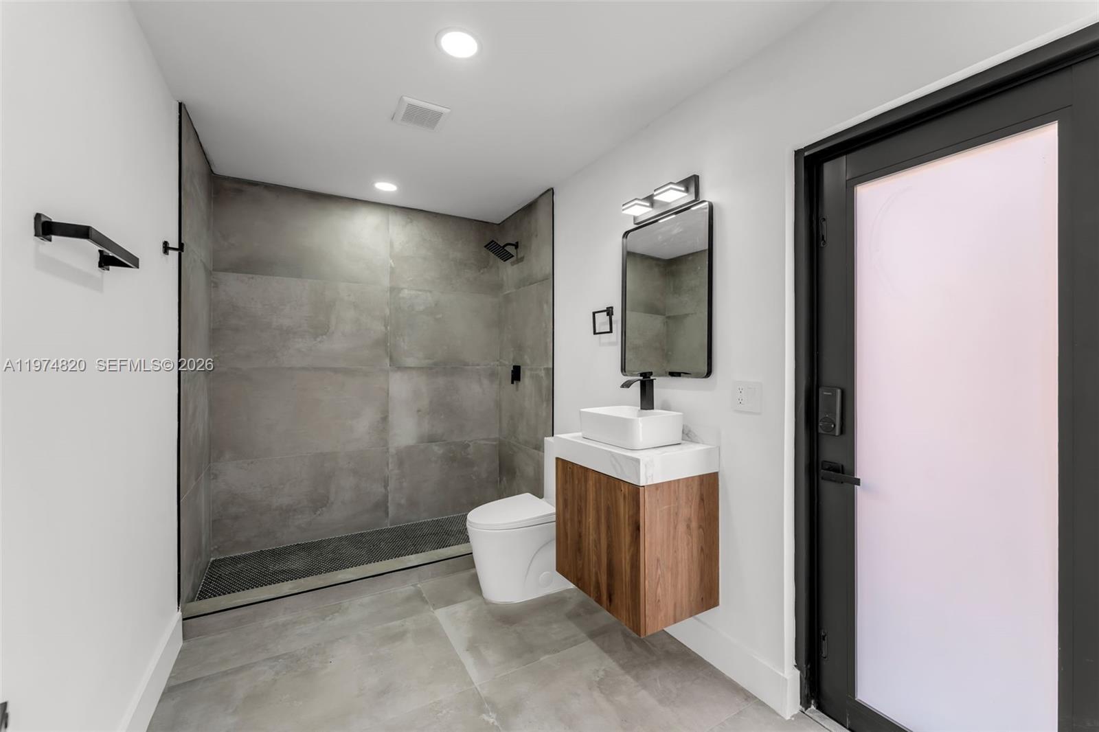 7120 Southwest 92nd Avenue Miami, FL 33173 - Photo 27 of 48 a bathroom with a toilet a sink and mirror