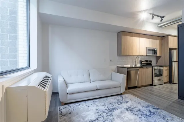 a living room with furniture and kitchen