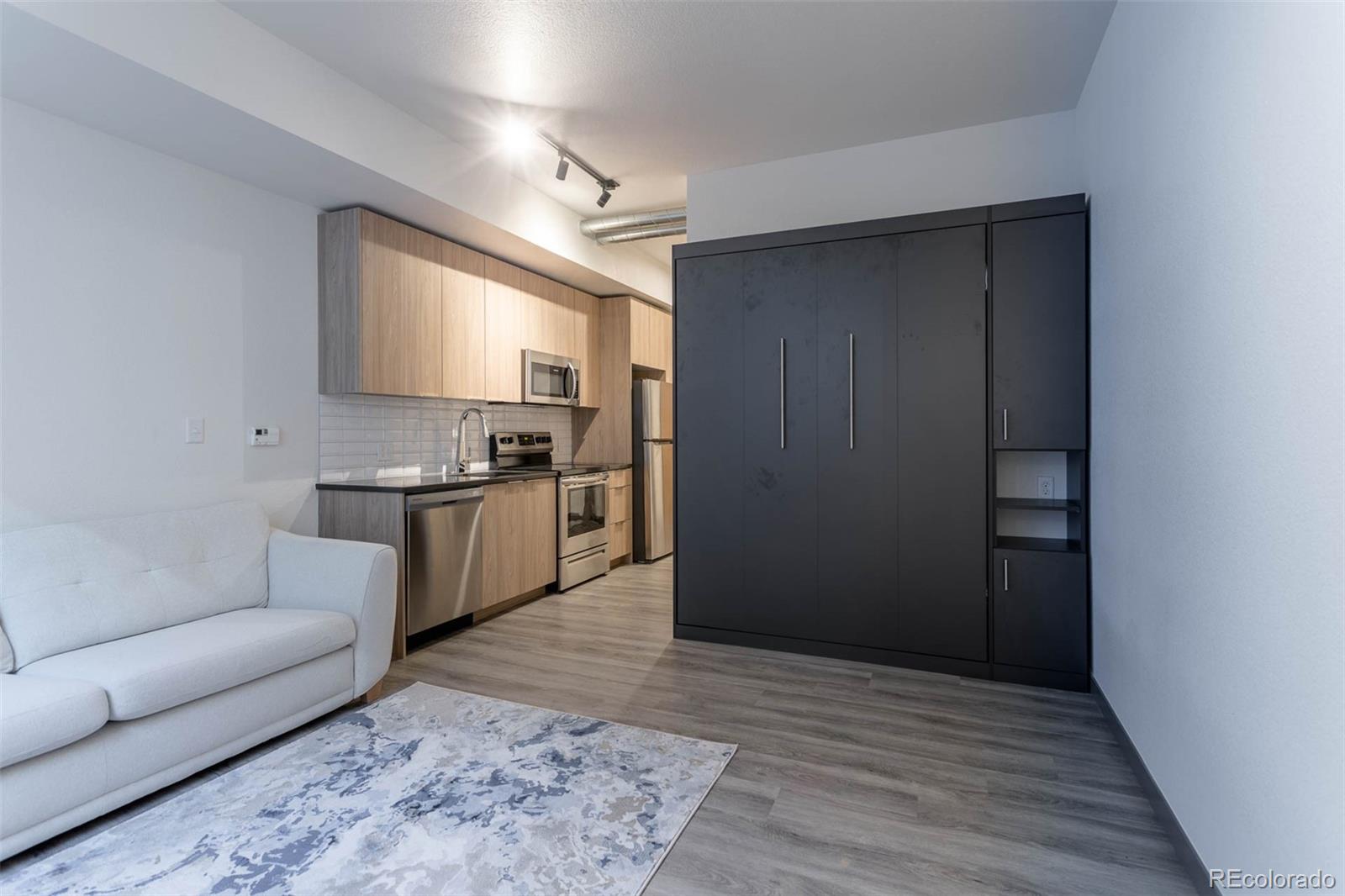 603 Inca Street, Unit 216 Denver, CO 80204 - Photo 13 of 22 a living room with stainless steel appliances kitchen island granite countertop furniture and a rug