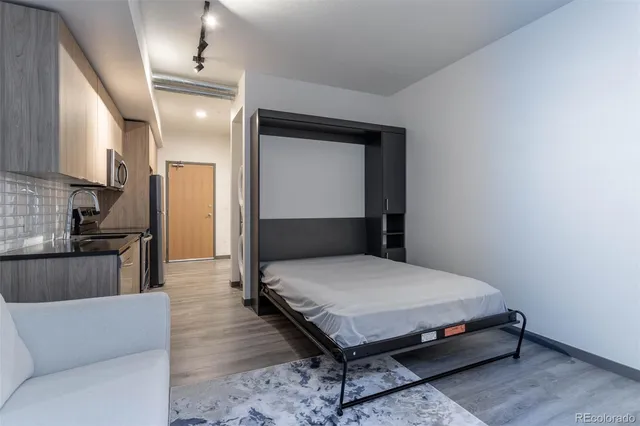 a bedroom with a bed and a view of kitchen