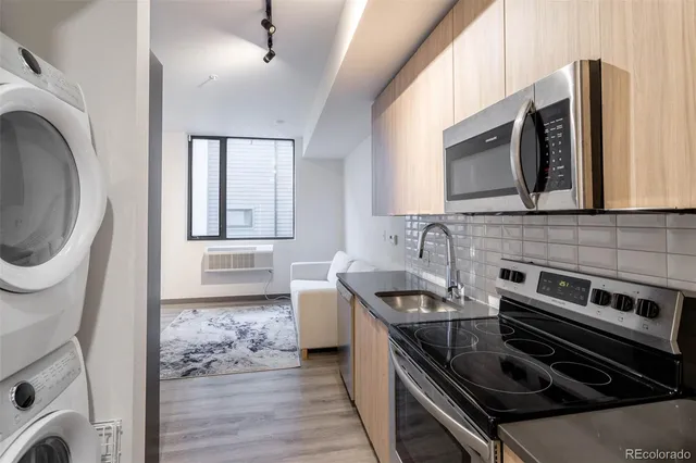 a kitchen with stainless steel appliances a stove a sink and a microwave