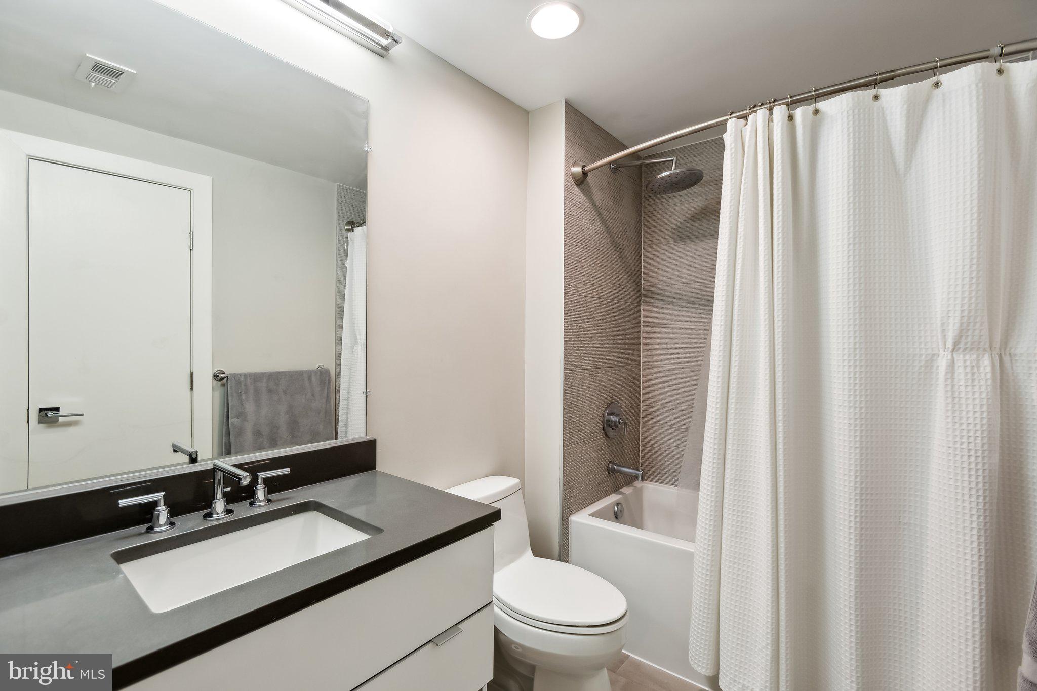 1311 13th Street Northwest, Unit T04 Washington, DC 20005 - Photo 15 of 18 a bathroom with a granite countertop sink toilet and shower