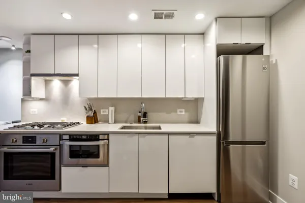a kitchen with a sink a refrigerator and cabinets
