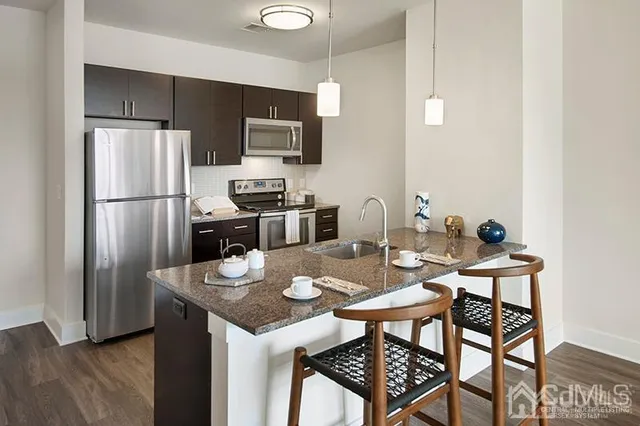 a kitchen with stainless steel appliances granite countertop a dining table and chairs