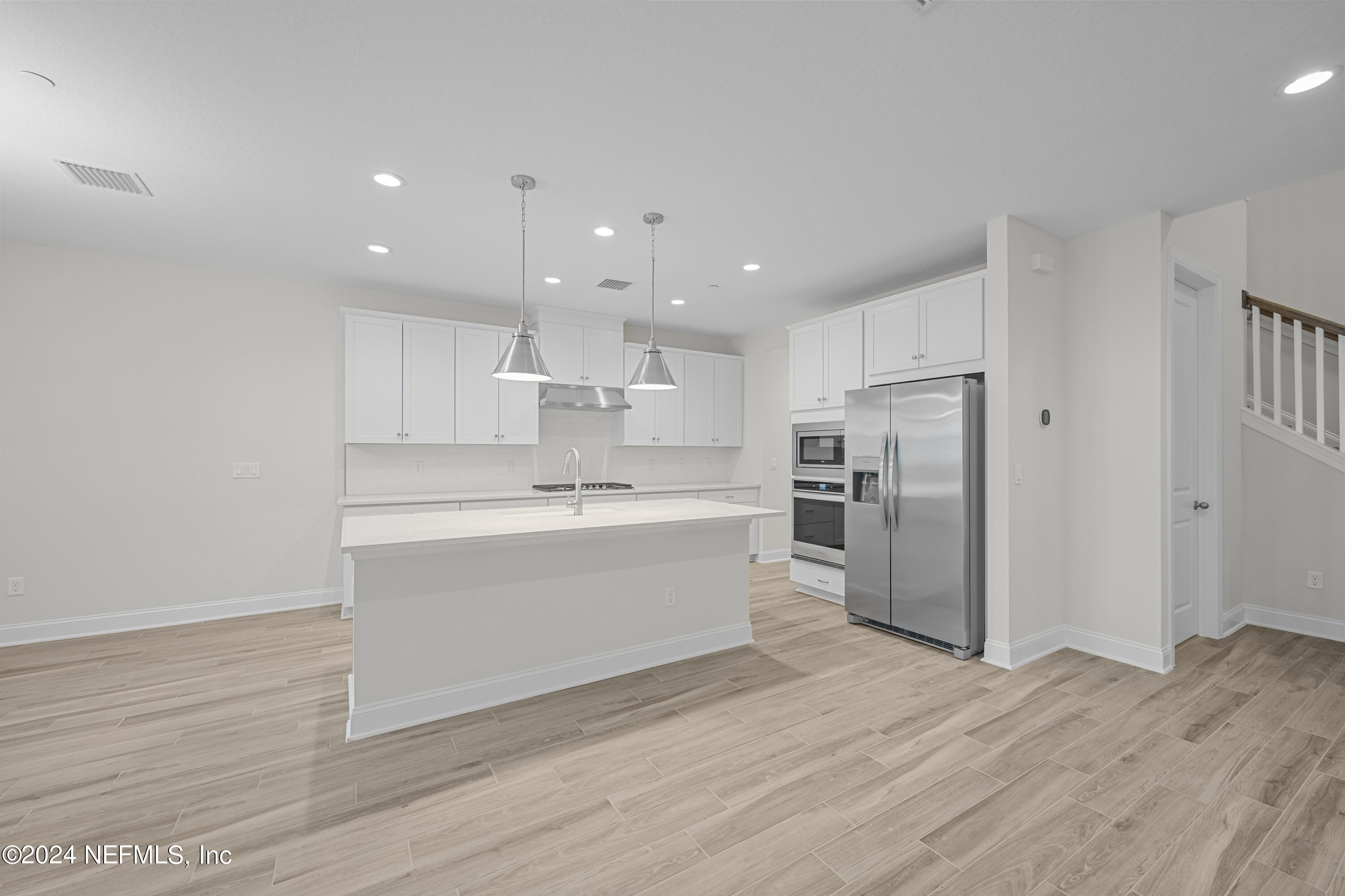 23 Oak Pk Drive St. Johns, FL 32259 - Photo 13 of 72 a large white kitchen with a refrigerator a sink dishwasher a stove and white cabinets with wooden floor
