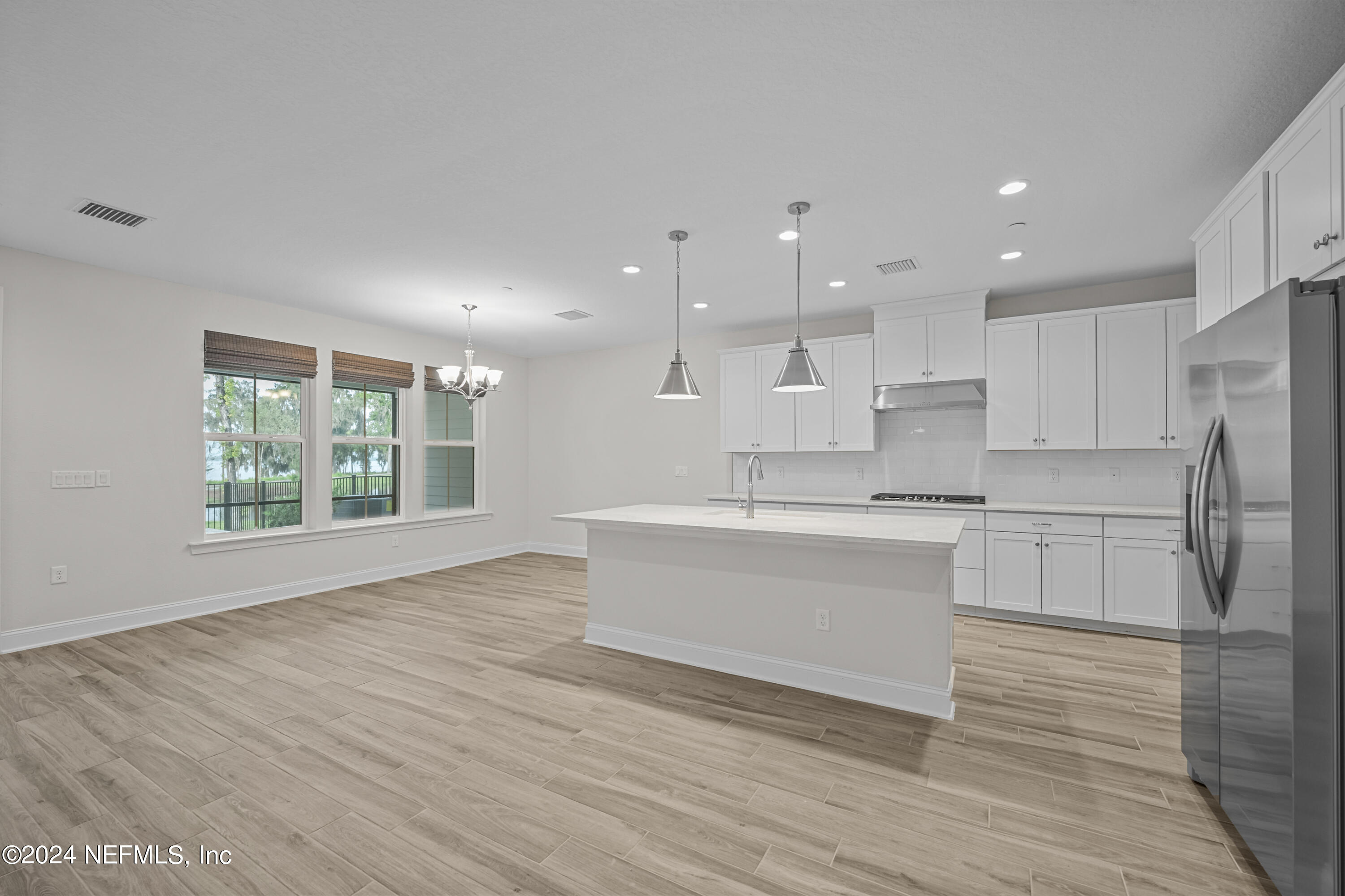23 Oak Pk Drive St. Johns, FL 32259 - Photo 14 of 72 a large white kitchen with kitchen island a sink wooden floor and a refrigerator