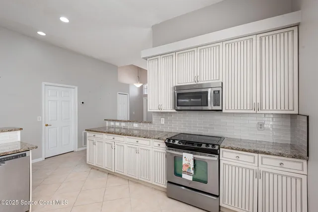 a kitchen with stainless steel appliances granite countertop a stove a sink and a microwave