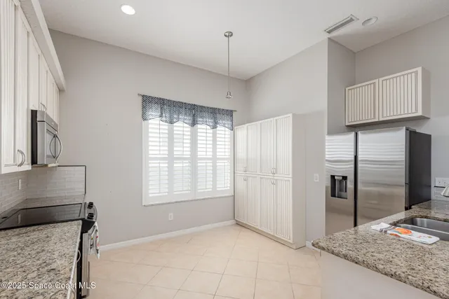 a kitchen with stainless steel appliances granite countertop a refrigerator and a stove
