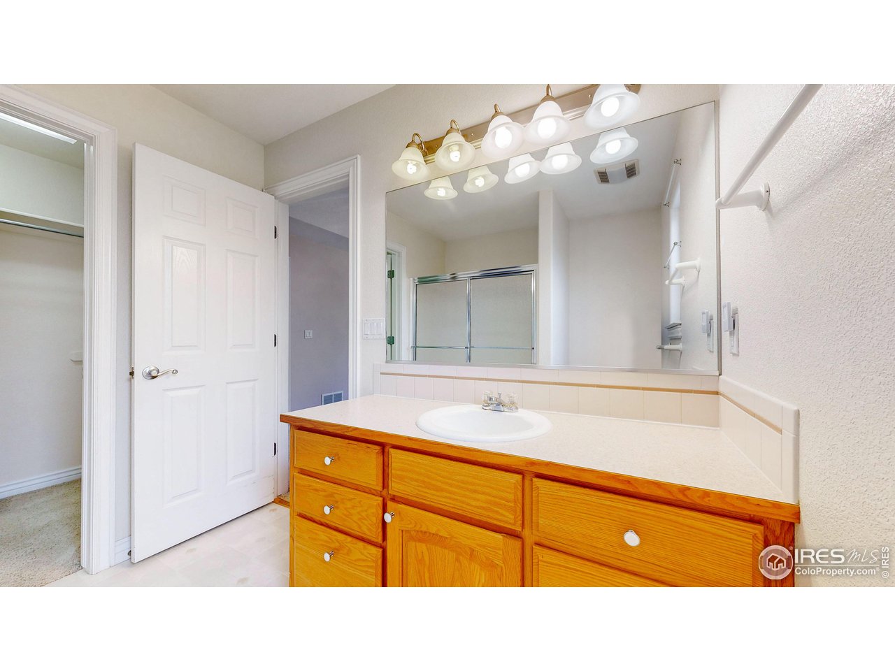 3585 West 20th Street Road Greeley, CO 80634 - Photo 19 of 32 a bathroom with a sink vanity and mirror