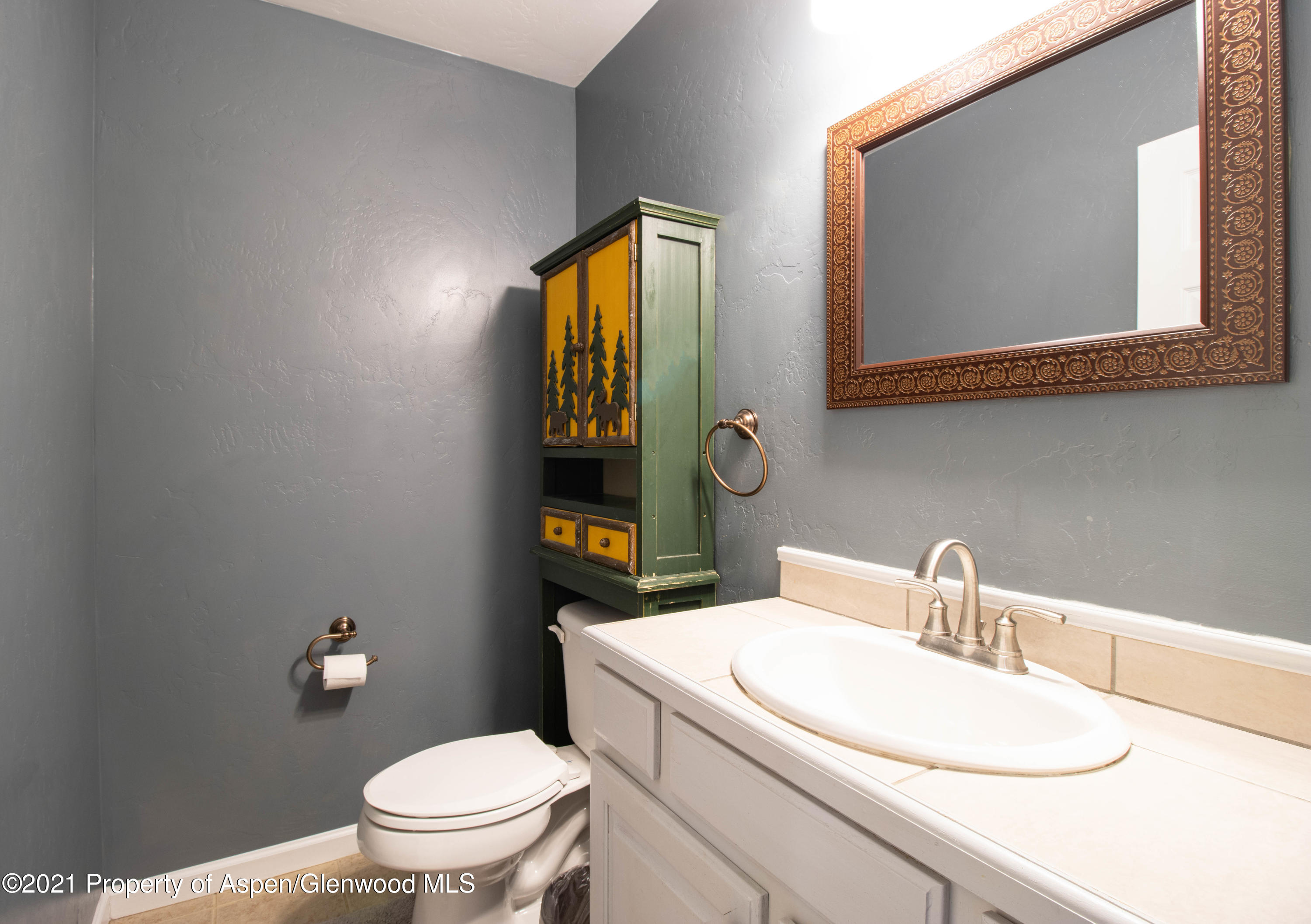 1259 East 18th Way Rifle, CO 81650 - Photo 9 of 17 a bathroom with a toilet sink and mirror