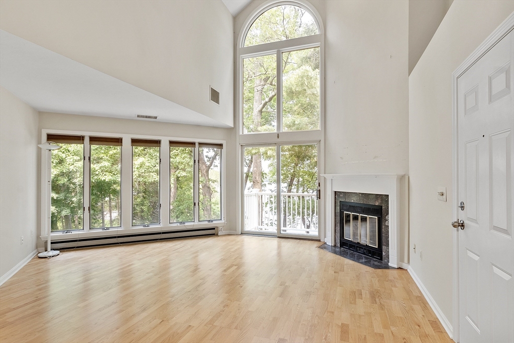 31 Pointe Rok Drive, Unit 31 Worcester, MA 01604 - Photo 18 of 32 wooden floor fireplace and windows in an empty room