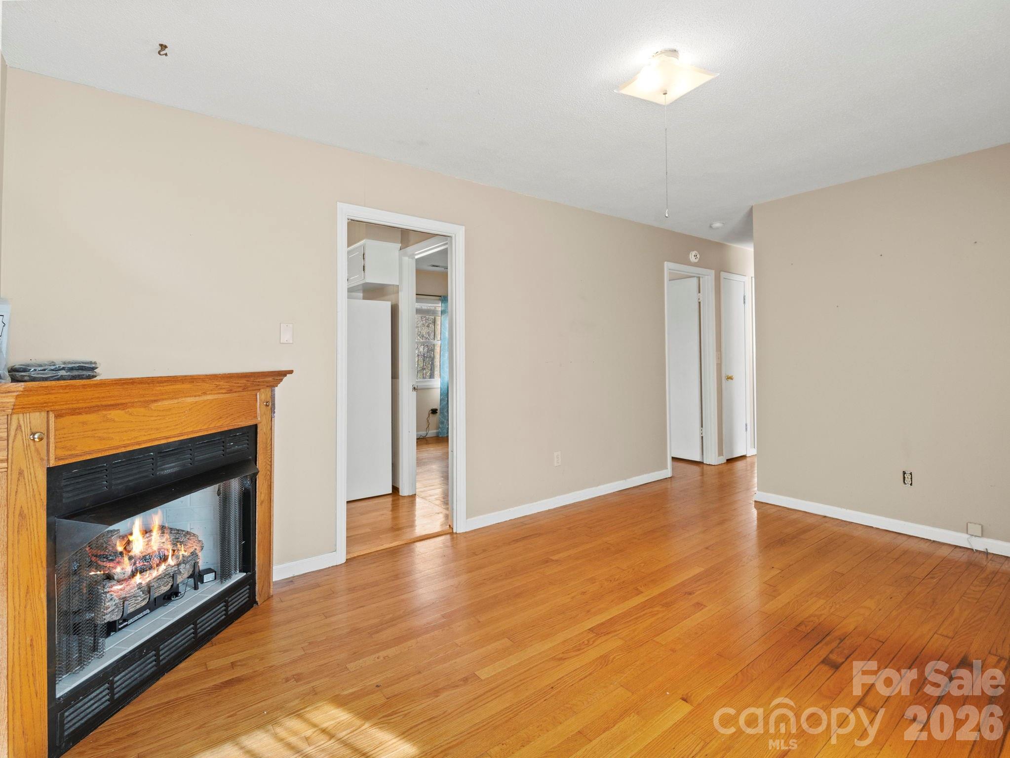 1429 Doggett Road Forest City, NC 28043 - Photo 16 of 33 a view of an empty room with wooden floor fireplace and a window