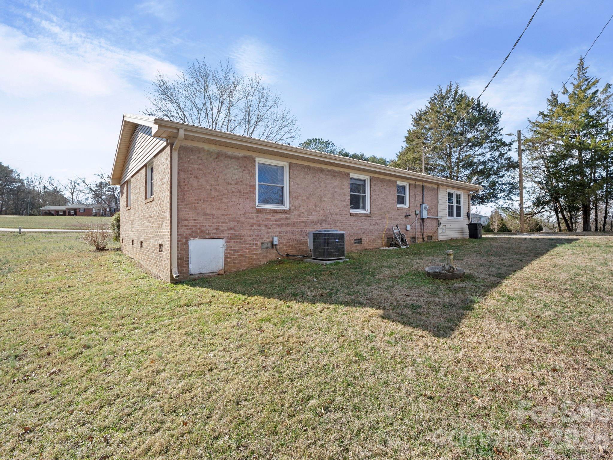 1429 Doggett Road Forest City, NC 28043 - Photo 6 of 33 a backyard of a house with large trees and barbeque oven