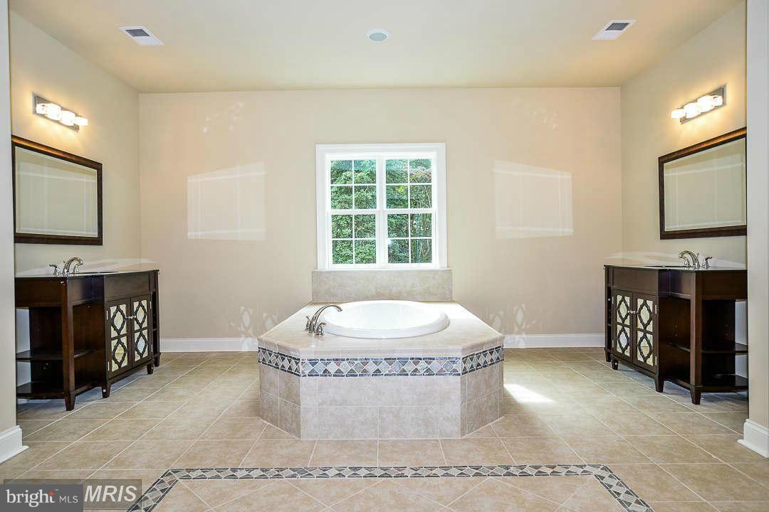8536 Old Keene Mill Road Springfield, VA 22152 - Photo 26 of 30 a spacious bathroom with a granite countertop sink a mirror and bathtub