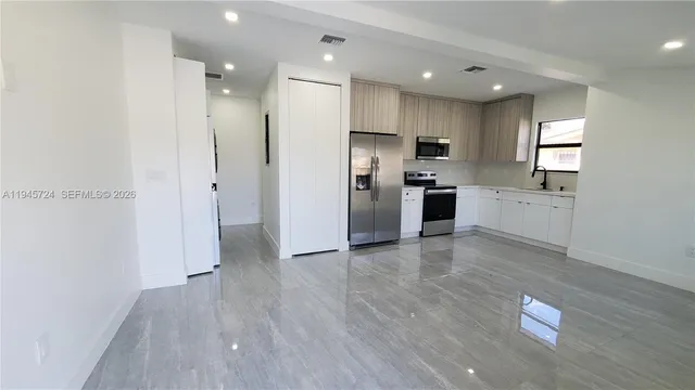 a large kitchen with a refrigerator and a sink