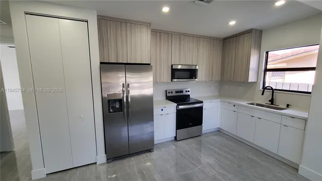 a kitchen with stainless steel appliances granite countertop a refrigerator a sink a stove a microwave and island