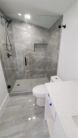 a bathroom with a shower a toilet and a shower