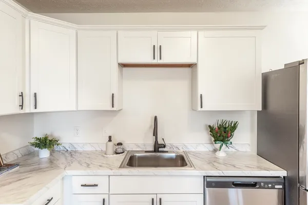 a kitchen with a refrigerator a sink and a stove top oven