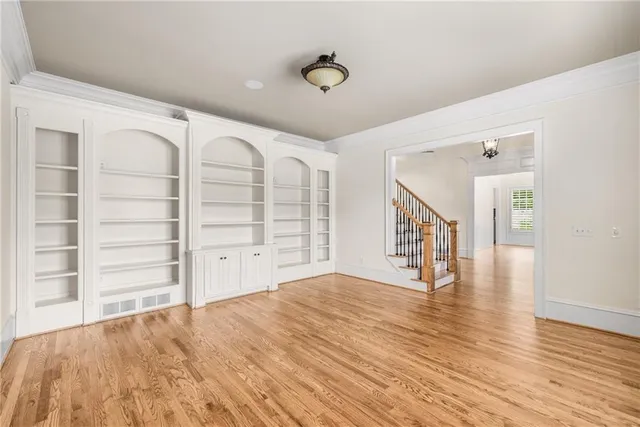 a view of an empty room with a window and wooden floor