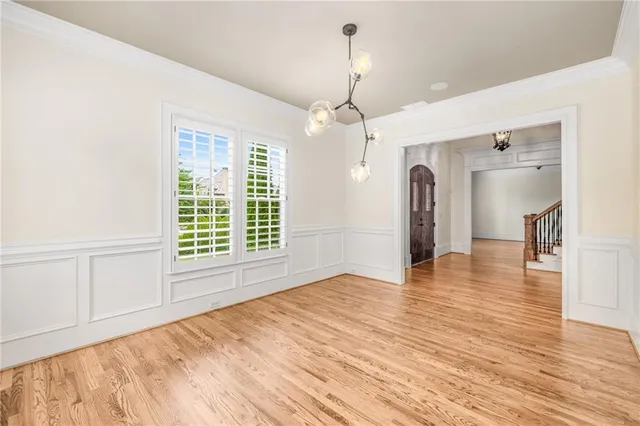 a view of an empty room with wooden floor fireplace and a window