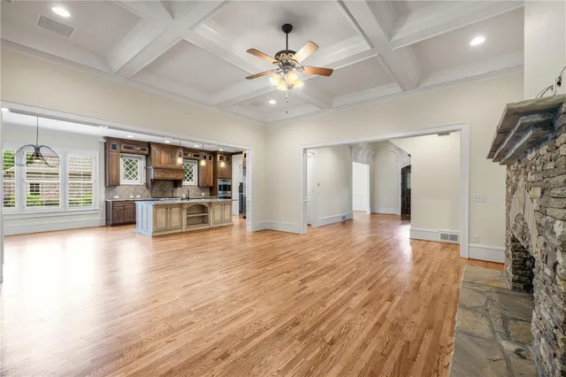 a large kitchen with kitchen island a stove a sink a refrigerator and a wooden floor